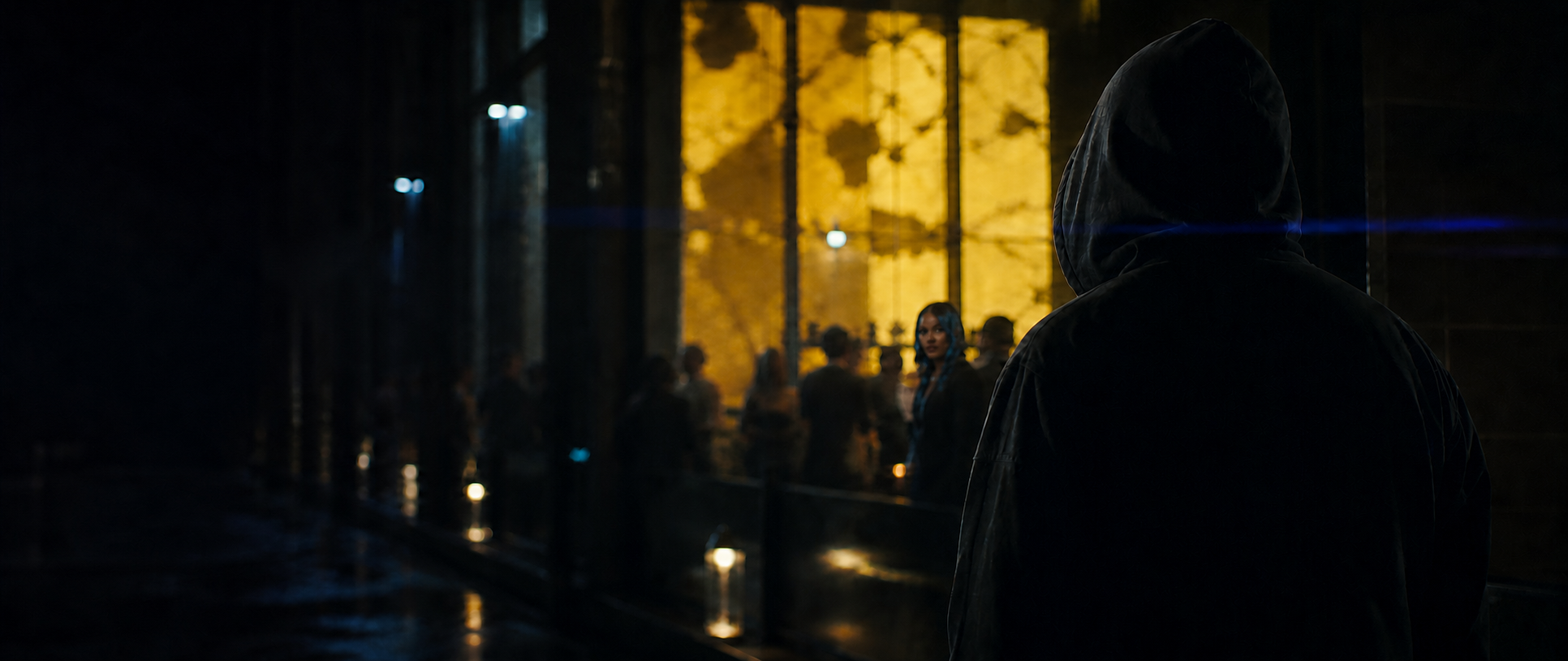 Hooded Uno watches Naomi through the blurred yellow glow of a nightclub.